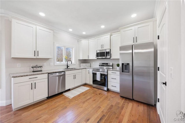 7717 Roberts St, Lenox, NY 13032 - kitchen featuring white cabinets, stainless steel appliances, light wood-style flooring, and a sink