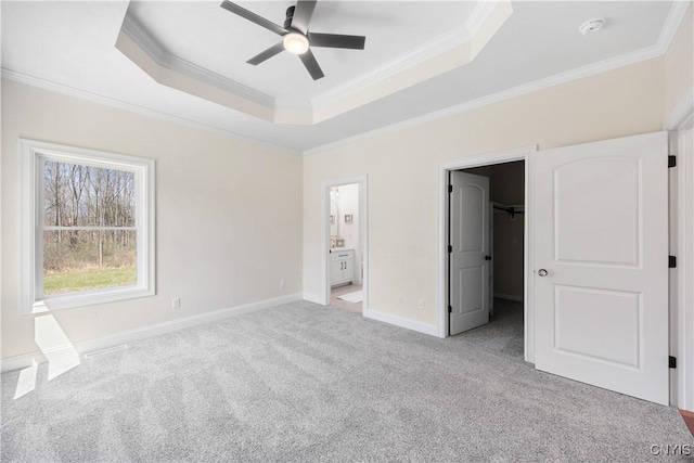 7717 Roberts St, Lenox, NY 13032 - unfurnished bedroom featuring a tray ceiling, baseboards, light colored carpet, a walk in closet, and ornamental molding