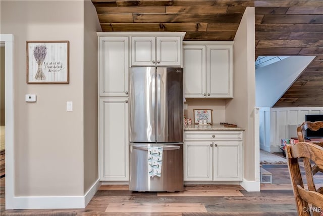 5410 N Shore Rd, Greig, NY 13312 - kitchen featuring baseboards, wood finished floors, freestanding refrigerator, and white cabinetry