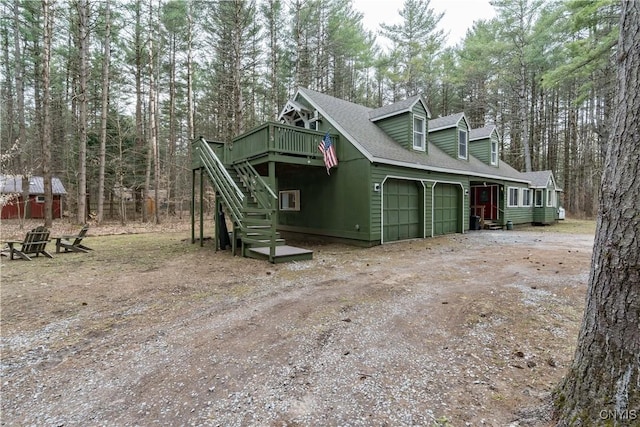 5410 N Shore Rd, Greig, NY 13312 - view of side of property featuring stairway, driveway, an attached garage, a wooden deck, and roof with shingles