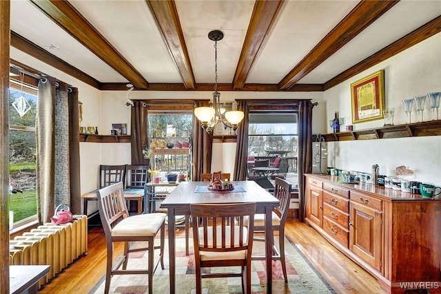 dining space featuring beam ceiling, a healthy amount of sunlight, a chandelier, and light wood-style flooring