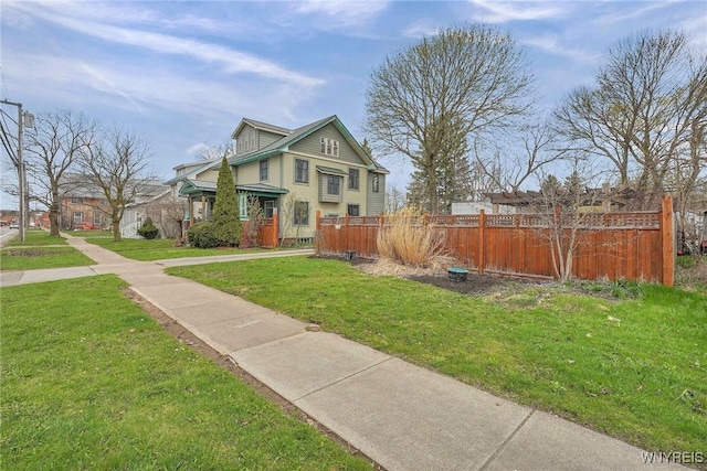 view of front facade with a front lawn and fence