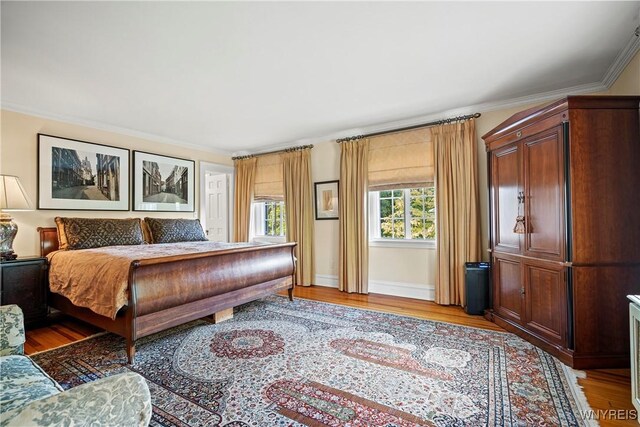 bedroom featuring light wood-type flooring and crown molding