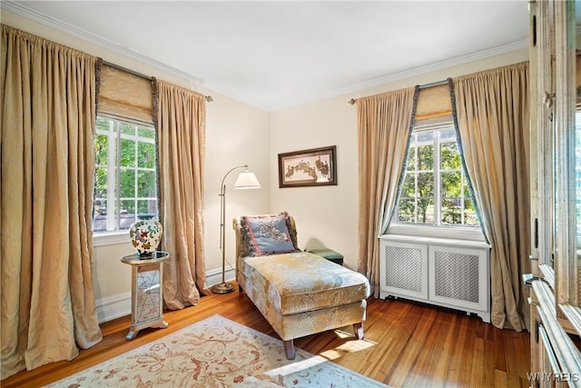 sitting room featuring crown molding, wood finished floors, and radiator heating unit