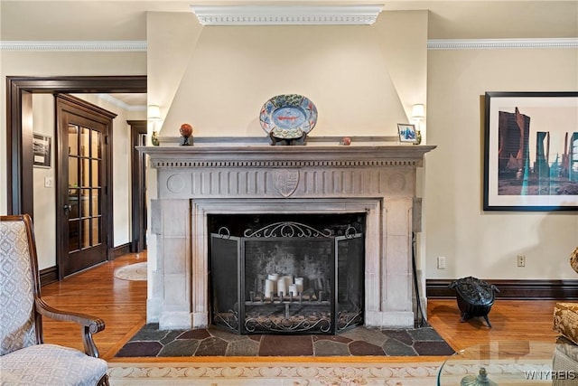 details featuring a fireplace with flush hearth, wood finished floors, crown molding, and baseboards