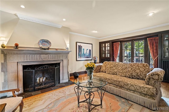 living room featuring baseboards, recessed lighting, wood finished floors, a large fireplace, and crown molding