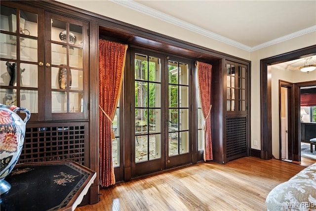 entryway featuring hardwood / wood-style flooring, baseboards, a wealth of natural light, and crown molding