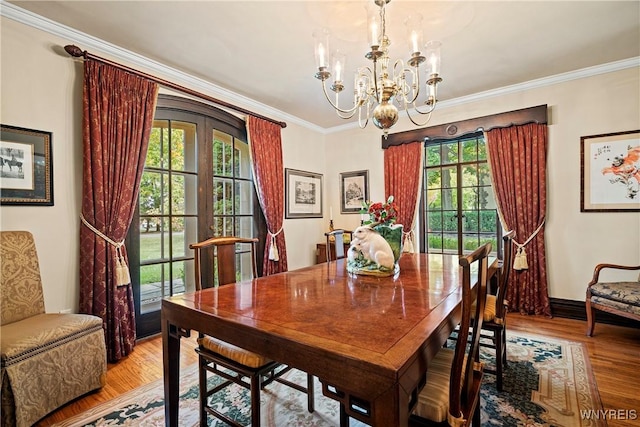 dining room with light wood-type flooring, a wealth of natural light, and a chandelier