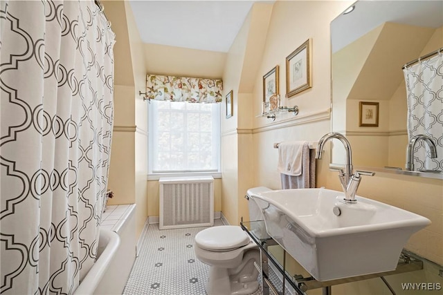 bathroom featuring tile patterned floors, a sink, shower / bath combination with curtain, radiator, and toilet