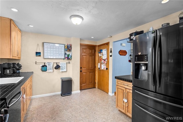 kitchen featuring fridge with ice dispenser, dark countertops, and baseboards