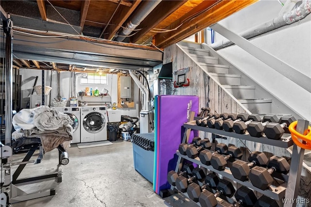 basement featuring washing machine and clothes dryer, electric panel, and stairway