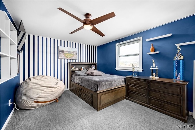 carpeted bedroom featuring wallpapered walls, a ceiling fan, and baseboards