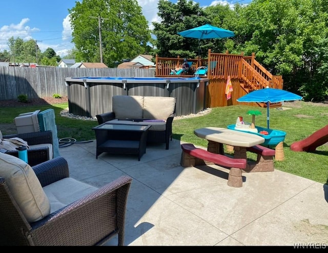 view of patio featuring fence, outdoor lounge area, a fenced in pool, and a playground