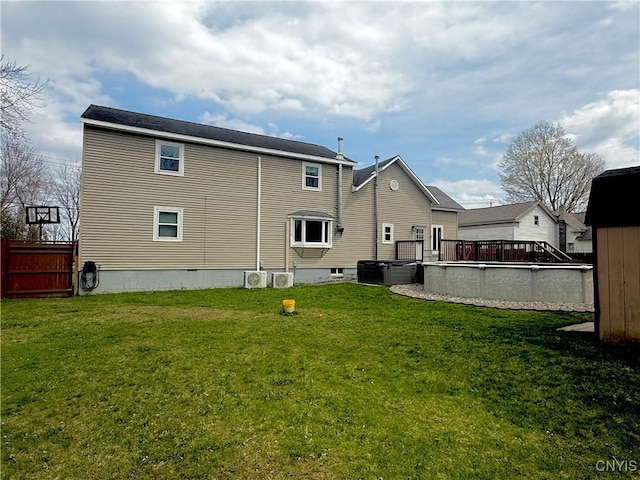 rear view of house featuring a lawn and a deck