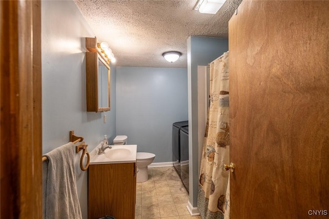 full bath with toilet, washing machine and clothes dryer, vanity, and a textured ceiling