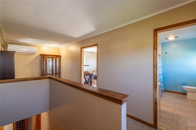 hall featuring an AC wall unit, baseboards, ornamental molding, and an upstairs landing