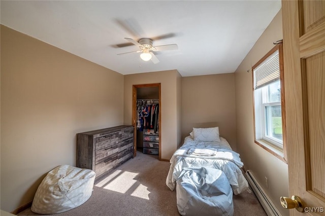 bedroom with a baseboard heating unit, light carpet, a ceiling fan, and a closet