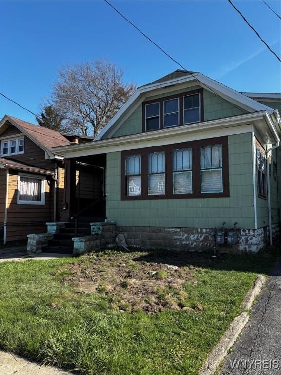 bungalow featuring a front lawn