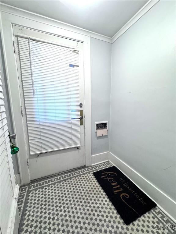 entryway featuring tile patterned floors, baseboards, and crown molding