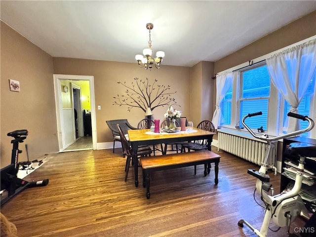 dining area featuring an inviting chandelier, radiator heating unit, wood finished floors, and baseboards
