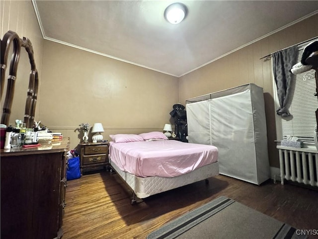 bedroom featuring radiator, ornamental molding, and wood finished floors