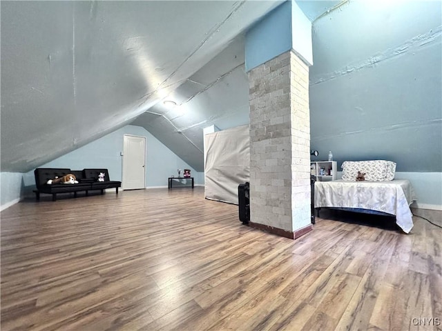 bonus room with lofted ceiling, baseboards, and wood finished floors