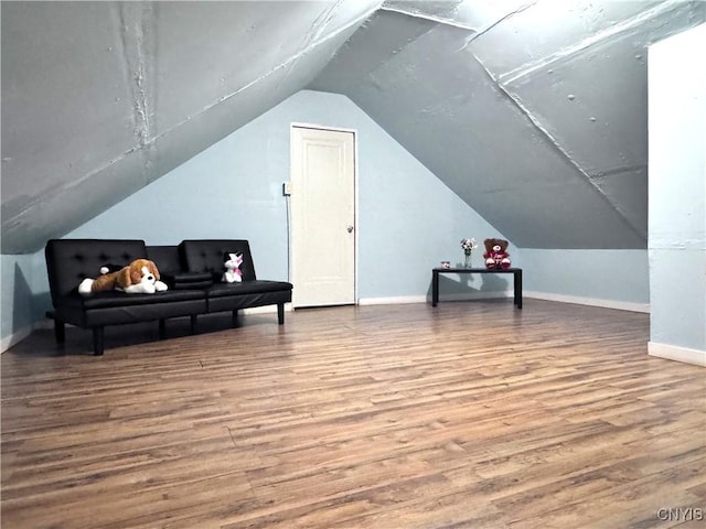 additional living space with vaulted ceiling, baseboards, and wood finished floors