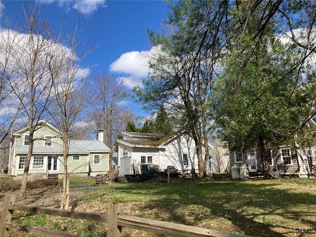 view of front of property with a chimney, fence, and a front yard