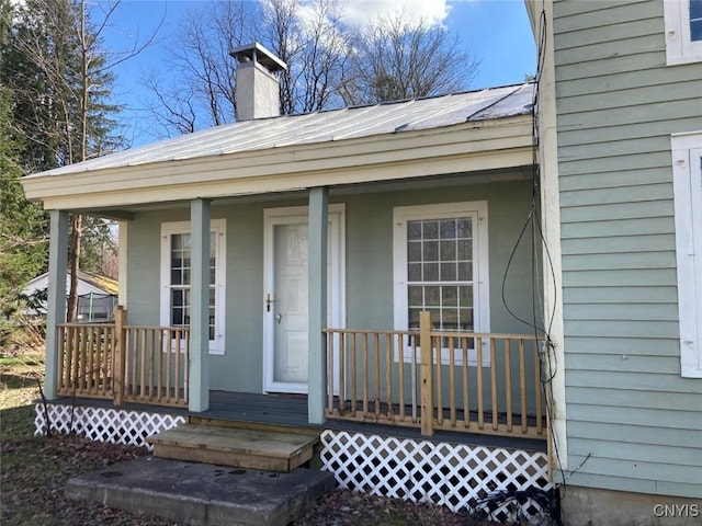 property entrance featuring a chimney and a porch