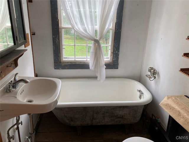 bathroom with a freestanding tub and a sink