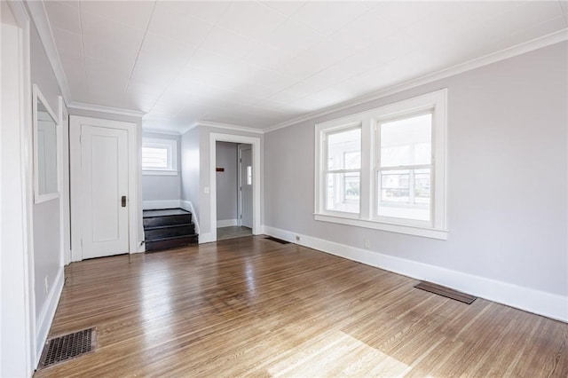unfurnished living room featuring stairs, visible vents, and wood finished floors