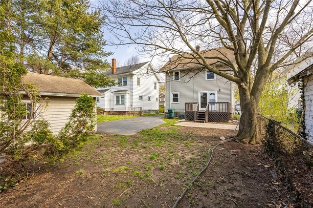 rear view of house featuring fence and a wooden deck