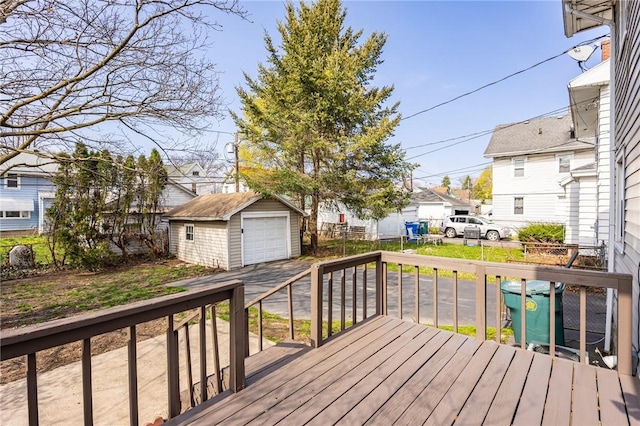wooden terrace with a detached garage, fence, an outdoor structure, and a residential view