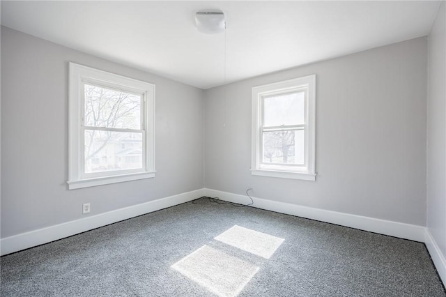 spare room featuring baseboards and carpet floors