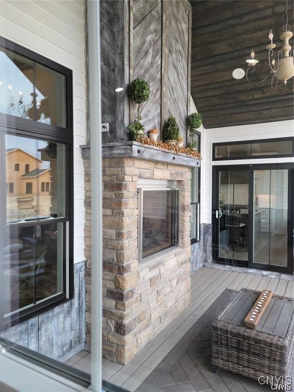 exterior space featuring a chandelier and a glass covered fireplace