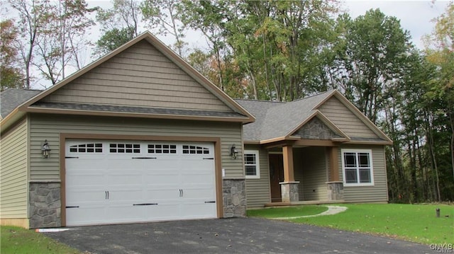 craftsman inspired home with a front yard, roof with shingles, stone siding, and aphalt driveway
