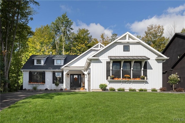 modern inspired farmhouse with a standing seam roof, a front lawn, and metal roof