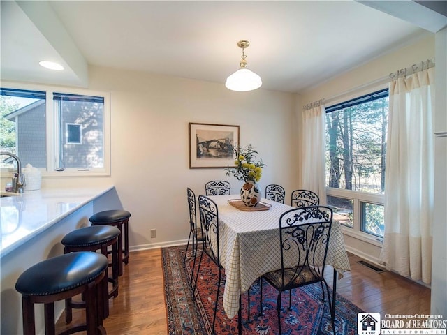 dining area featuring wood finished floors, visible vents, and baseboards