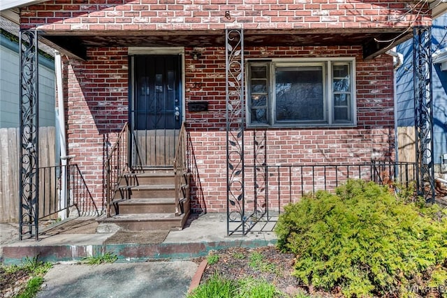 entrance to property featuring brick siding