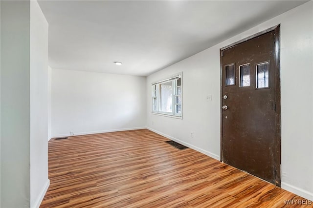 entryway featuring baseboards, visible vents, and wood finished floors