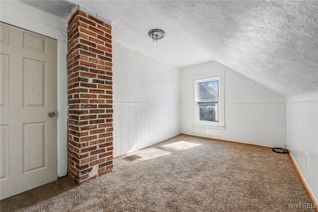 bonus room featuring visible vents, a textured ceiling, carpet floors, and vaulted ceiling