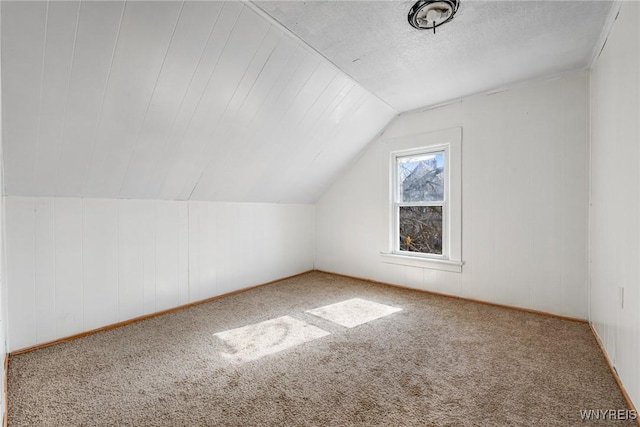 additional living space featuring carpet and lofted ceiling