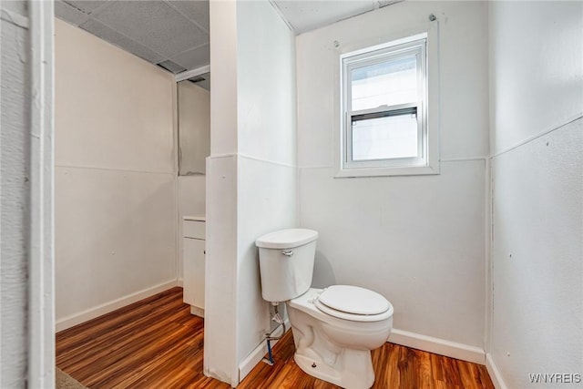 bathroom with wood finished floors, toilet, and baseboards