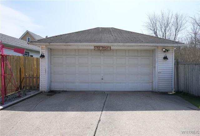 detached garage featuring fence