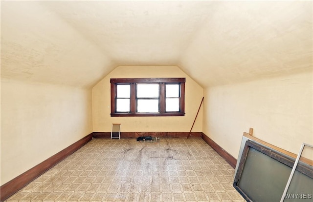 additional living space with vaulted ceiling and baseboards