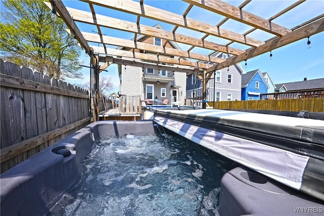 exterior space with a fenced backyard, a pergola, and a hot tub