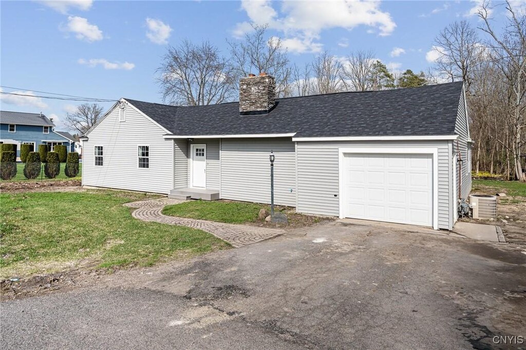 8758 Whiting Rd, Cicero, NY 13039 - view of front of house with driveway, a shingled roof, an attached garage, and a chimney