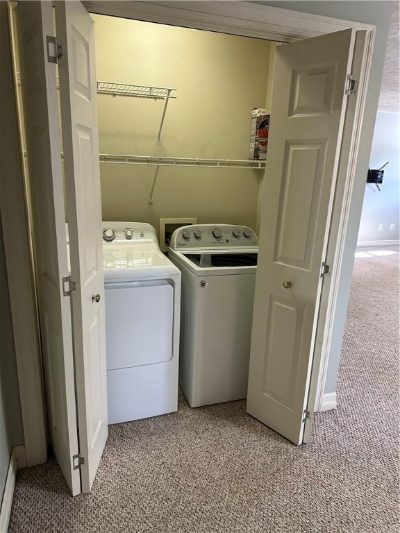 laundry room featuring washing machine and clothes dryer, laundry area, and light colored carpet