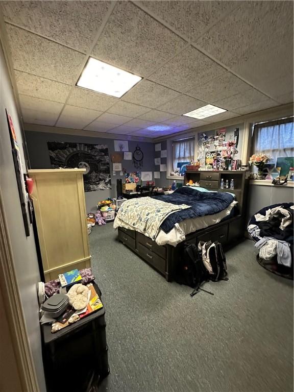 carpeted bedroom featuring a paneled ceiling