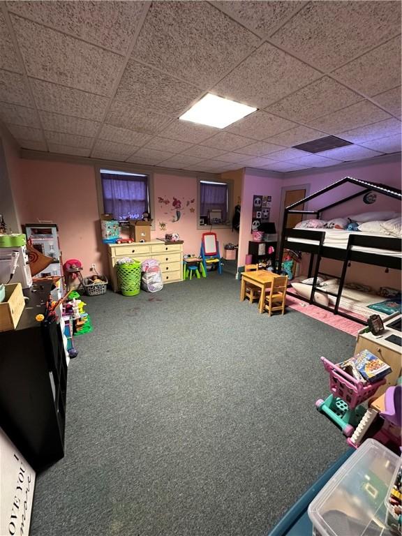 game room with a paneled ceiling and carpet flooring